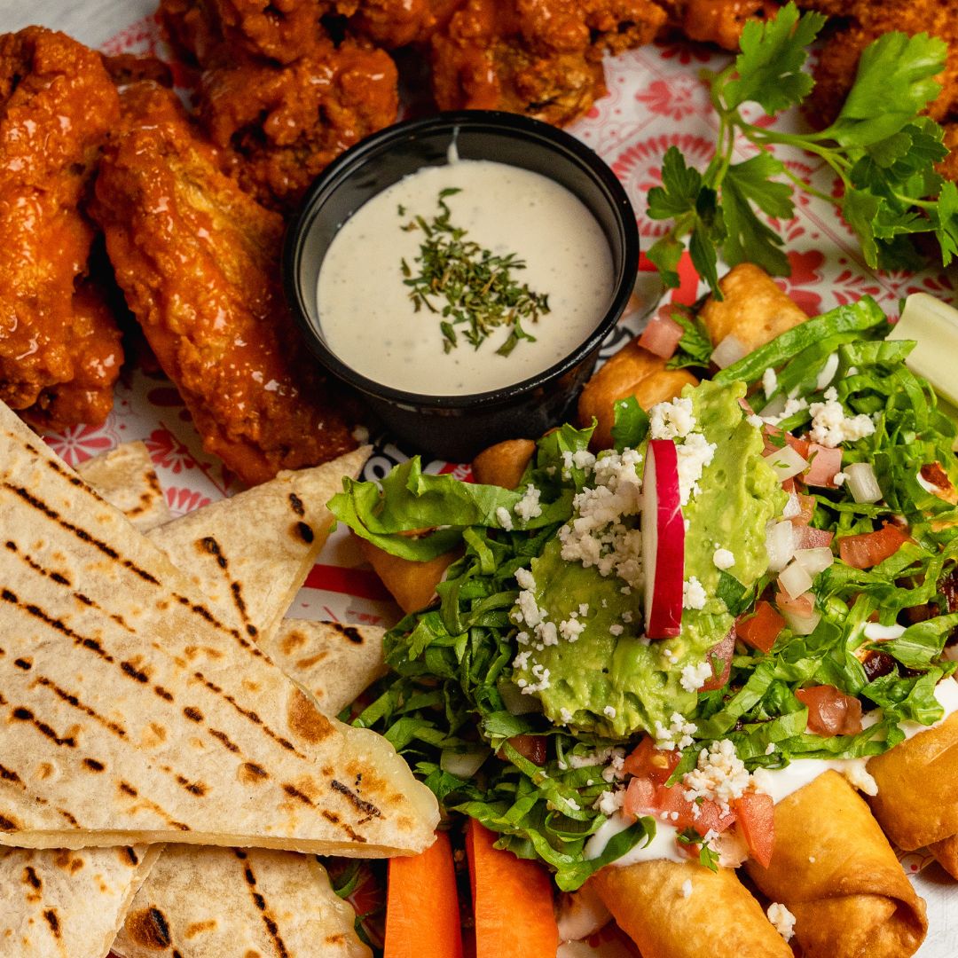 Sharing platter with buffalo wings, quesadillas, taquitos and guacamole