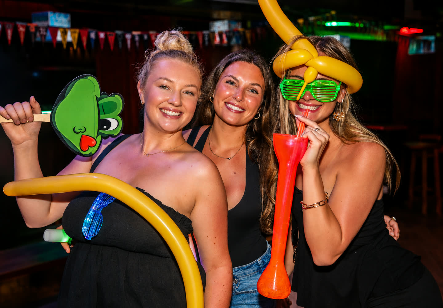 Friends with balloons and party glasses at Señor Frog’s Los Cabos Party Zone