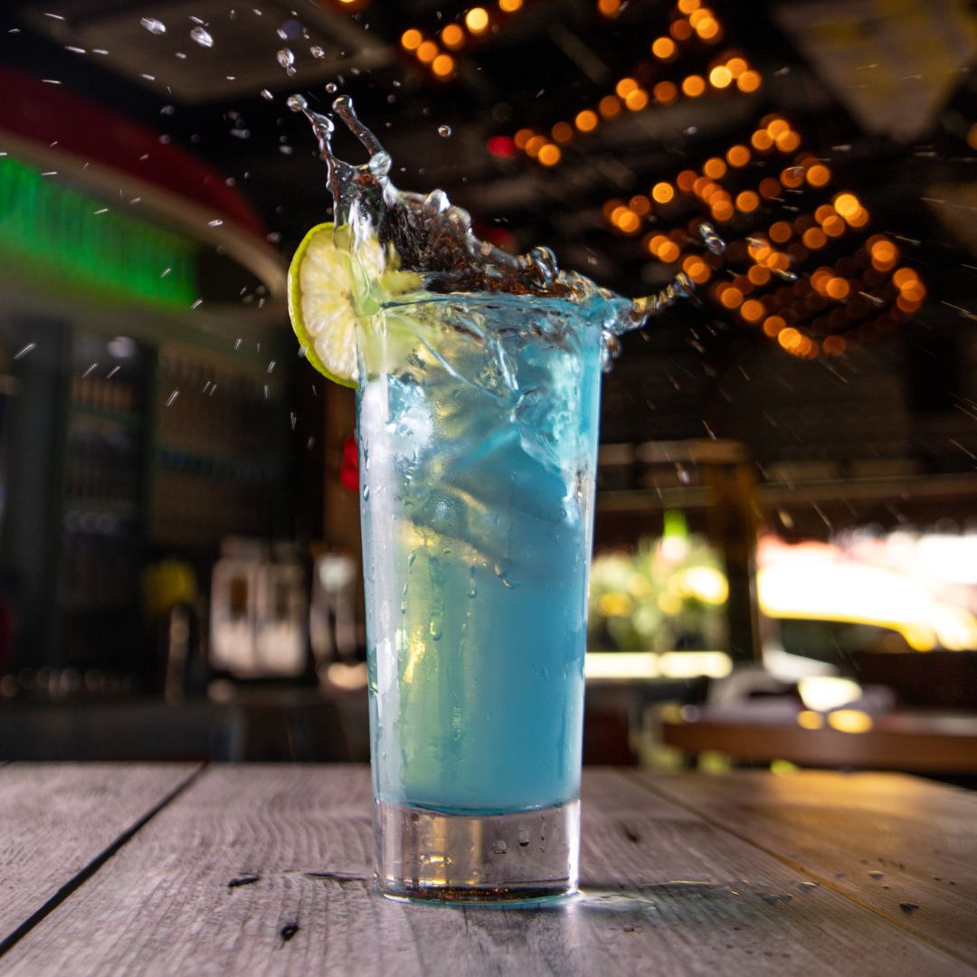 Blue cocktail splashing with a lime wheel at Señor Frog’s Playa del Carmen