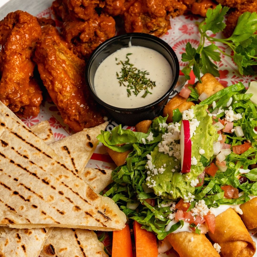 Sharing platter with buffalo wings, quesadillas, taquitos and guacamole at Señor Frog’s Playa del Carmen